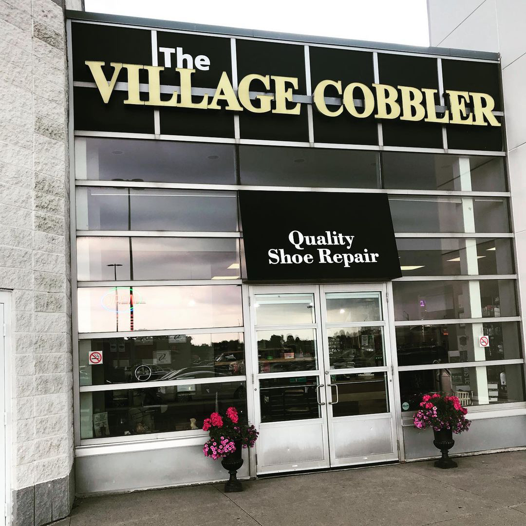 Image of the village cobblers storefront sign from the outside looking in